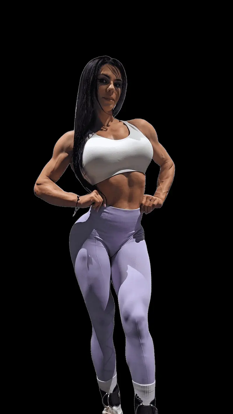 Natasha posando de pie con top blanco y mallas lilas sobre fondo negro